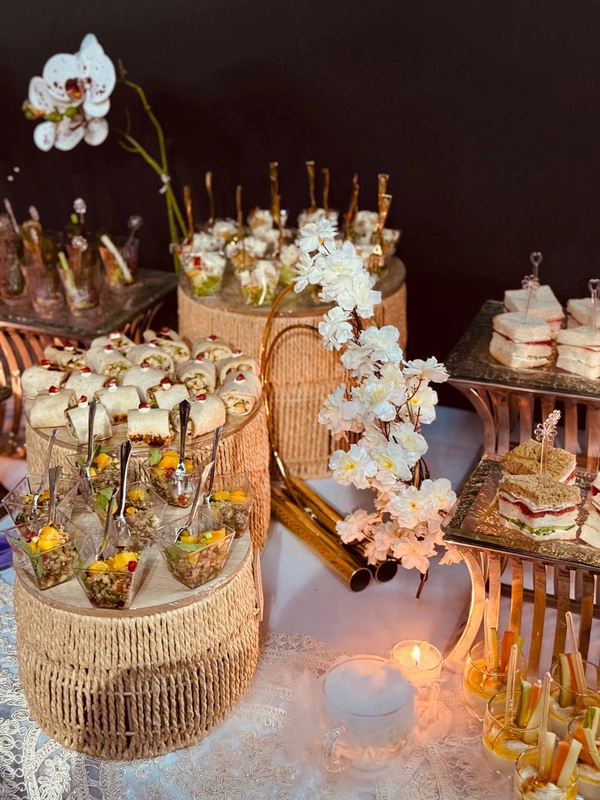 Event canape display with salads, wraps, sandwiches and white orchids
