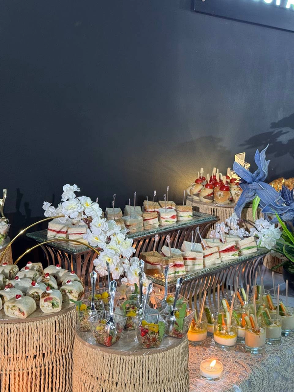 Tiered sandwich and salad display with woven stands and orchids