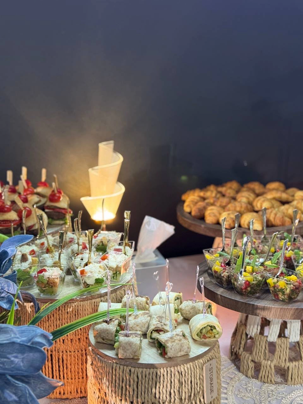 Catering wraps, individual salad cups and croissants on woven display stands